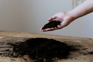 Ahşap bir zemine saçılmış toprak, topraktan yapılmış kalp, bir kalp çizer
