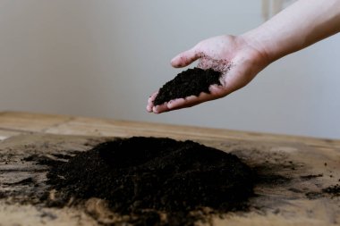 Ahşap bir zemine saçılmış toprak, topraktan yapılmış kalp, bir kalp çizer