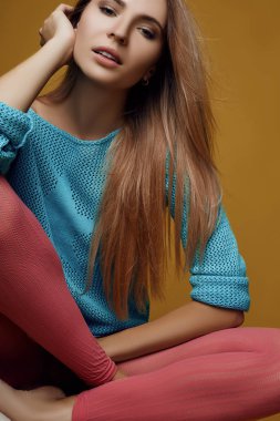 Kız rahat oturma parlak giysiler içinde poz