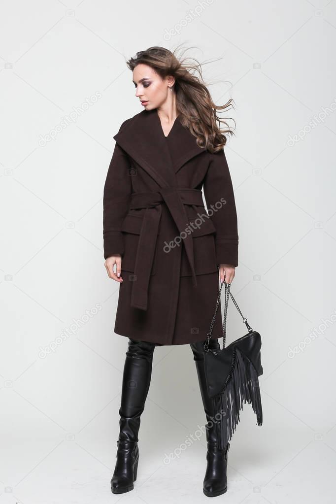 Woman in autumn brown coat with belt isolated