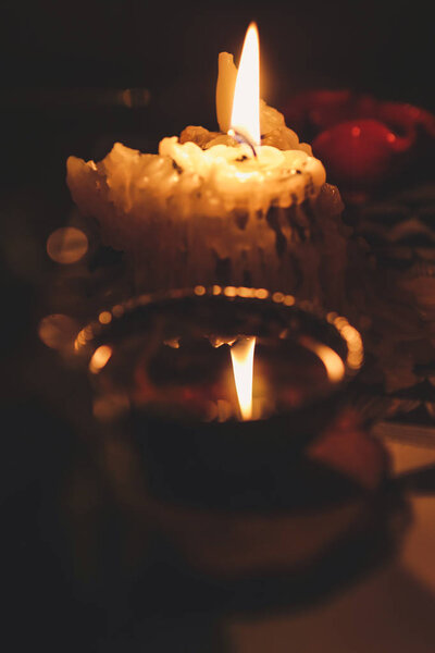 Burning short candle, reflection of fire in tea bowl during tea ceremony