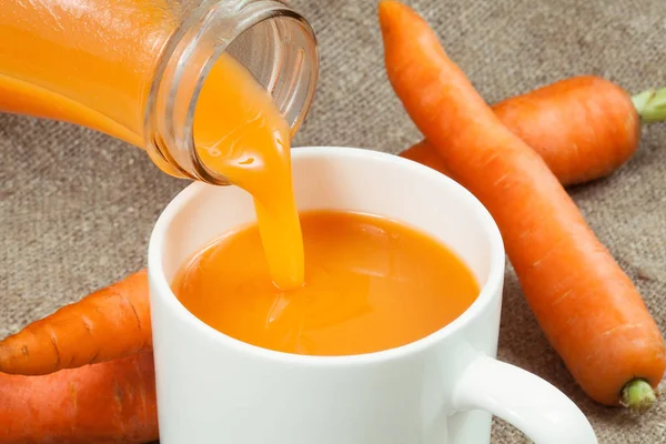 Jugo de zanahoria vertido en una taza —  Fotos de Stock