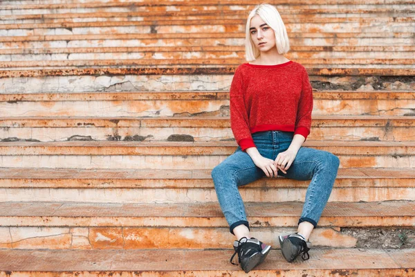 Chica rubia sentada en escaleras oxidadas — Foto de Stock