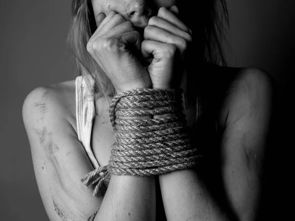 Scared woman with bound hands