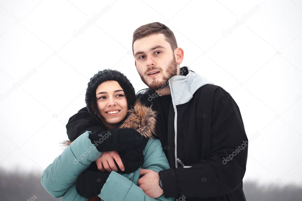 couple embracing on winter field.