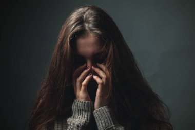 Studio gri arka plan üzerinde üzgün kadın portresi