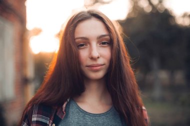 Gün batımı arka plan üzerinde genç kadın portresi