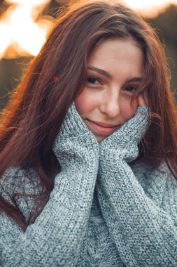 Gün batımı arka yüzünde ellerinde olan kadın portresi