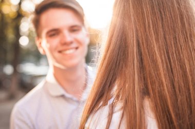 Genç çift güneş ışığı altında sokakta dalga