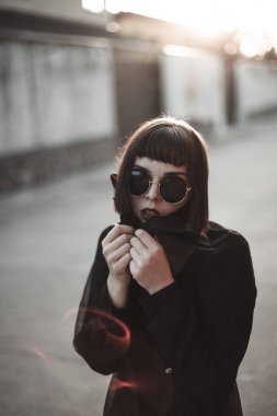 sokakta poz yuvarlak gözlüklü genç kadın portresi