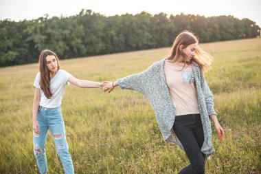 Yeşil alan üzerinde yürüyen iki genç kadın