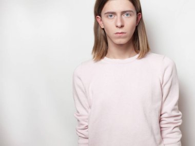 Çift cinsiyetli genç adam pembe kazaklı beyaz arka plan üzerinde poz