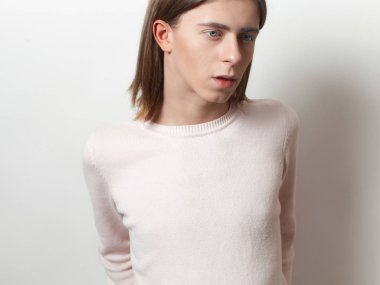 Çift cinsiyetli genç adam pembe kazaklı beyaz arka plan üzerinde poz