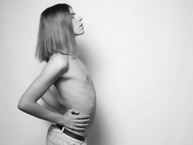 Çift cinsiyetli genç adamın üstsüz poz profilde tek renkli fotoğraf 