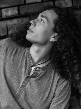 Genç adam tuğla duvara yakın poz tek renkli fotoğraf