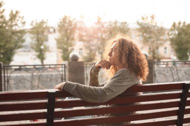 Waterfront alanı yakınında bankta oturan düşünceli adam 