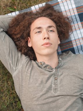 genç adam ekose parkta çim üzerinde yalan