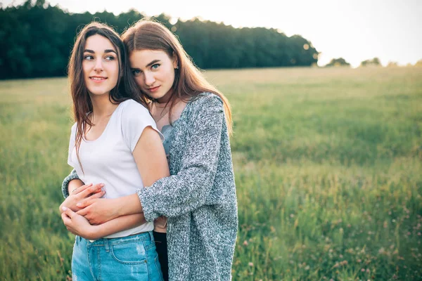 Δύο Κορίτσια Αγκάλιασμα Στο Πράσινο Πεδίο Στην Διάρκεια Της Ημέρας — Φωτογραφία Αρχείου