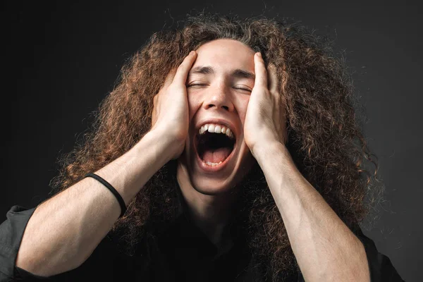 Portrait of young man screaming in studio
