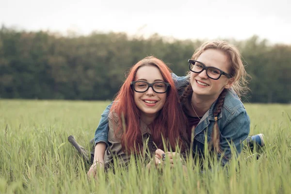 つの若い女性を草の上に敷設 — ストック写真