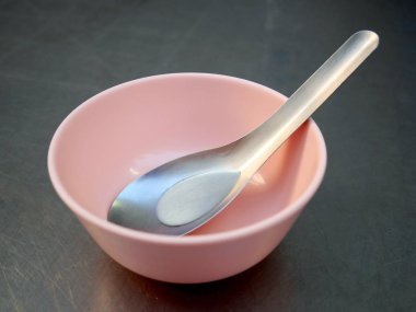 Kısa kaşık ve küçük bir pembe plastik kase