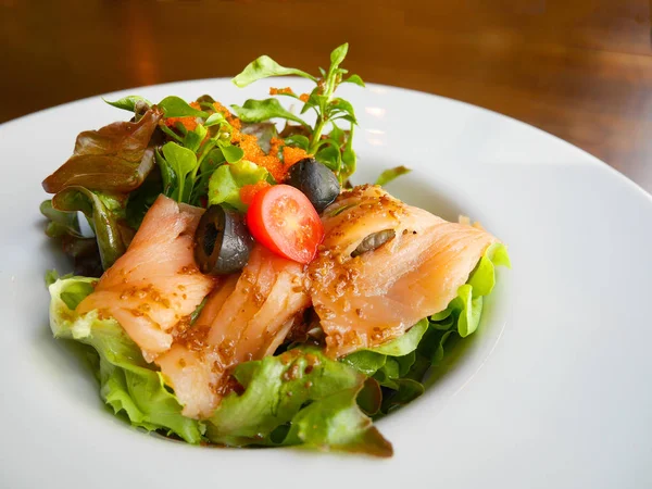 Dekore edilmiş beyaz tabak içinde füme somon salata