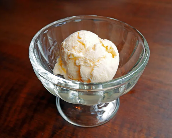 Kepçe bir cam kabın içinde vanilyalı dondurma ile