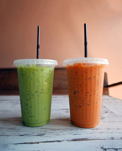 Buzlu soğuk yeşil çay ve plastik bardak portakal süt çay