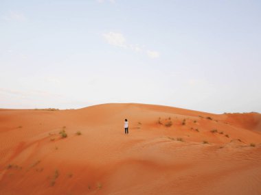 Beyaz, tek başına duran Asya kadın Gezgin solo, Muscat, Umman Sultanlığı başkenti dört saat sürücüsünden büyük kumulları tarafından Wahiba, büyük bir çöl alanı ile çevrili.