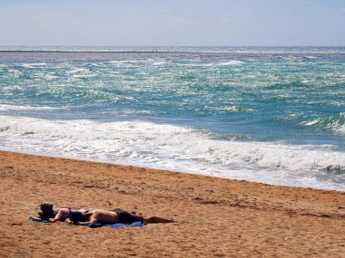Mai Khao Beach rüzgarlı bir plaj bronzlaşma çift güneş