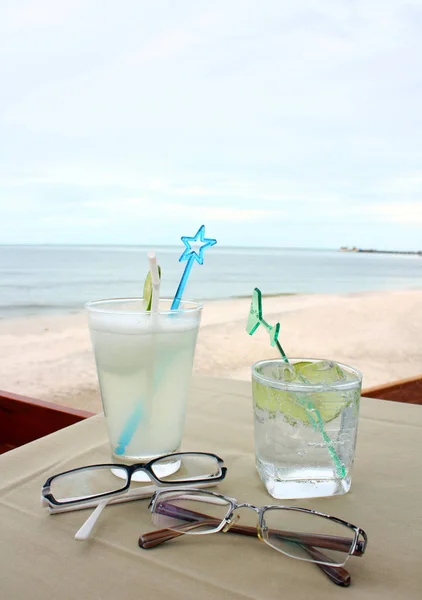 İçecek için iki ve plajda masada gözlük gözlük