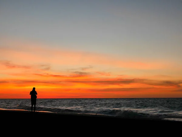 Siluet adam alarak resmi günbatımı plaj için