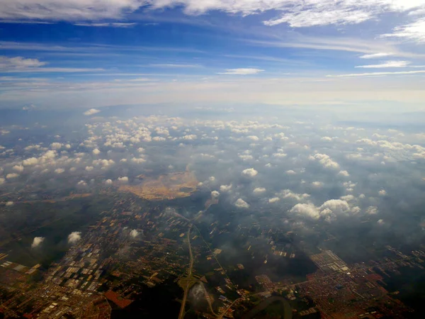 Aerial cloudscape with city below — Stock Photo, Image