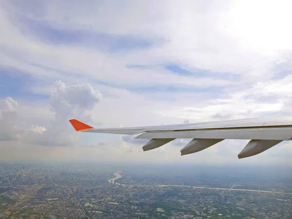 Ala de avión y cielo azul con la ciudad de Bangkok debajo — Foto de Stock