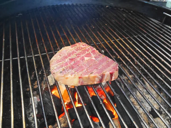 Morceau de porc cru sur le barbecue de pique-nique four à griller en cours de cuisson . — Photo