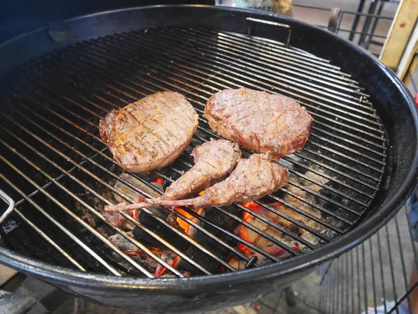 Piknik Barbekü üzerinde pişmiş biftek parçalarını hizmet için bekleyen fırın ızgara.