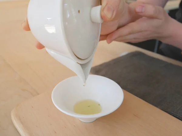 Yeşil çay bir çay salonu küçük beyaz seramik bardağa dökülür varlık.