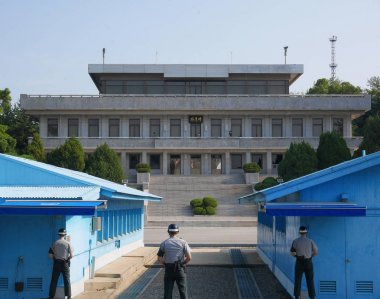 PANMUNJEON, SOUTH KOREA - SEPTEMBER 26, 2017: DMZ or DPRK demilitarized zone from South Korea facing North Korea, with South Korean soldiers looking toward North side which only one soldier visible clipart