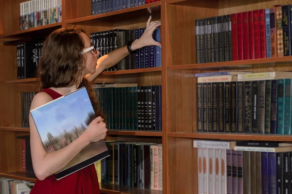 Female student reaching for a book