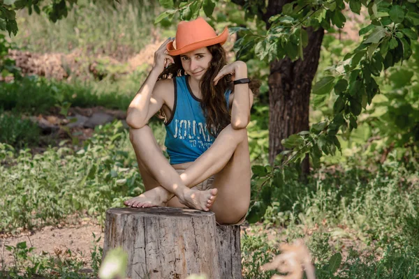 Uma garota encaracolada tocando seu chapéu de cowboy . — Fotografia de Stock