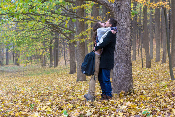 Lovers met in the woods after classes. Happy students firmly hugged.