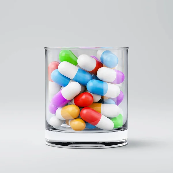 Pilules colorées dans un verre à boire — Photo