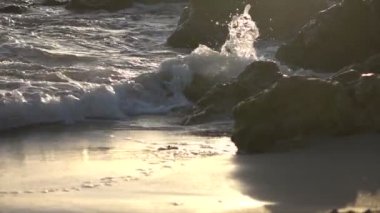 Günbatımı altın boyalı yavaş dalgalar