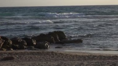 Dalgalar kayaların üzerinde Beach üzerinde yavaş yavaş yıkama 