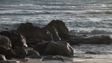 Yavaş yavaş üzerinde kayalık sahil çökmesini dalgalar