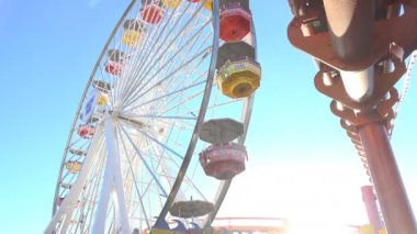 Ayakta aşağıda Santa Monica Pier dönme dolap olarak döner