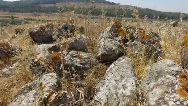 Περπάτημα χαμηλά στο έδαφος, ανάμεσα σε βράχους από αρχαίο ρωμαϊκό δρόμο — Αρχείο Βίντεο