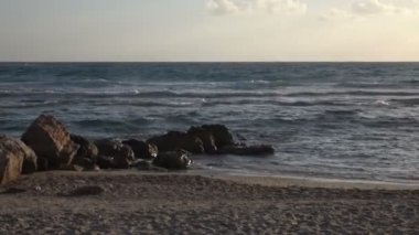 Bulaşık sörf ile gün batımında sahilde kayalık fosillerini