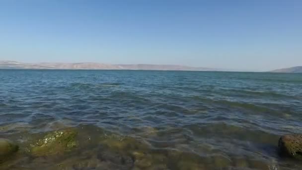 Langzaam lopen achteruit vanaf rand van de zee van Galilea en rotsachtige kust — Stockvideo