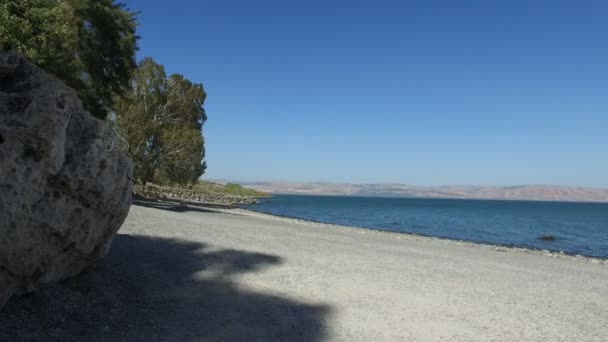 Caminar hacia atrás con el mar de Galilea en primer plano — Vídeo de stock